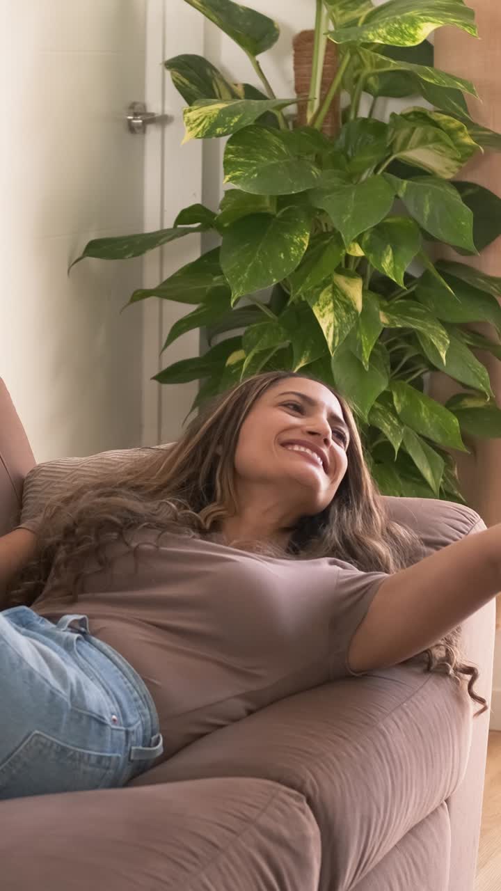 Woman enjoying in living room with TV remote in hand