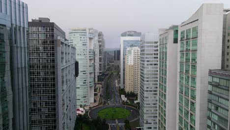 deslizándose entre edificios altos de santa fe - rascacielos en la ciudad de méxico sobre carreteras casi vacías durante la pandemia de covid-19 y el cielo nublado