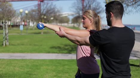 concentrated woman training arms with dumbbells.