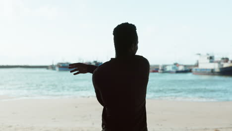 Rücken,-Silhouette-Und-Ein-Mann,-Der-Sich-Am-Strand-Streckt