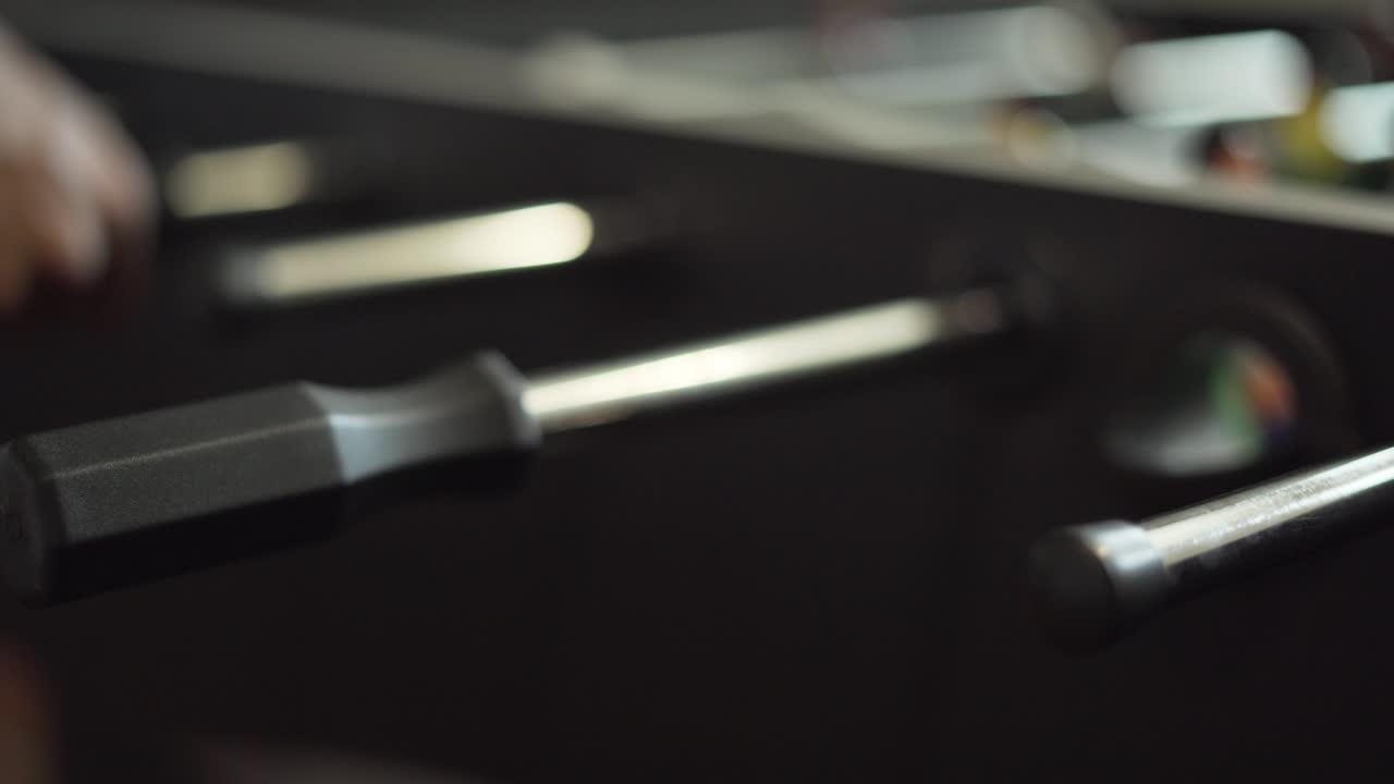 primer plano de manos jugando al futbolín