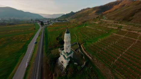 FPV-following-traintracks-and-shooting-up-into-a-roundshot-of-a-memorial,-lower-Austria