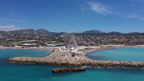 aerial back traveling over borely beach sunny day marseille big wheel attraction