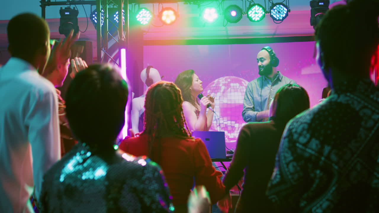 People Dancing at a Nightclub with DJ Performing
