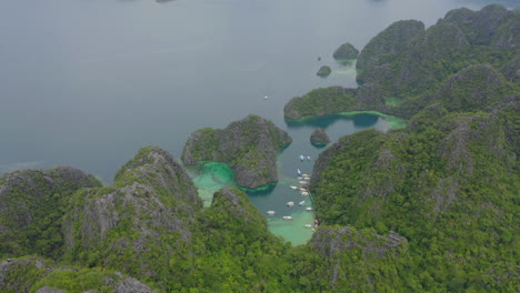 A-drone-video-of-a-tropical-setting-over-the-ocean-and-jungle-on-an-overcast-day-in-the-Philippines-with-boats