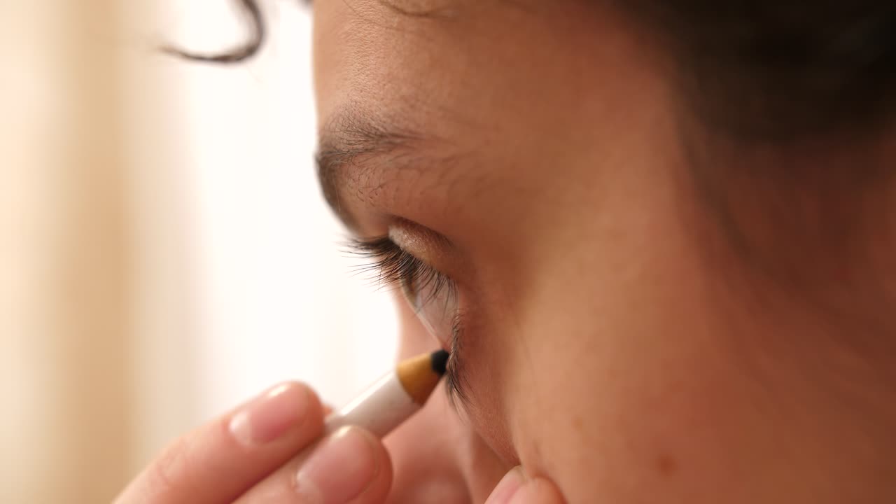 Close Up of Woman Applying Eyeliner to Her Eye