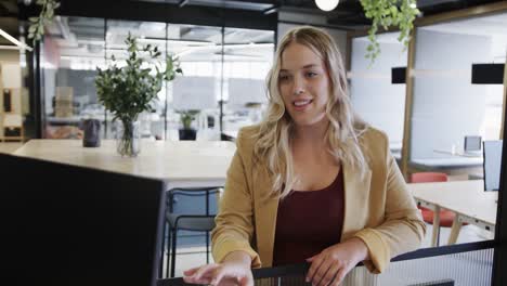 happy plus size caucasian casual businesswoman having video call at office lounge