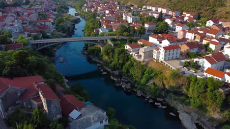 aerial drone 4k view of neretva river with cars going over bridge in mostar, bosnia and herzegovina