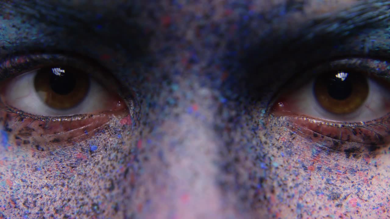 close up woman eyes wearing face paint body art mysterious female performer with colorful makeup light fading to dark