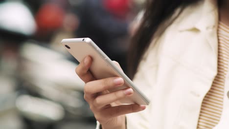 Handheld-view-of-young-Vietnamese-woman-with-cell-phone