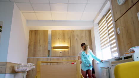 caucasian couple standing in the ward of maternity hospital. man stroking his wife's back to sooth woman.