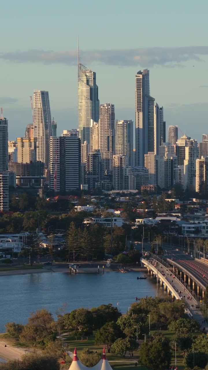 Riprese aeree verticali con panoramica a sinistra attraverso il ponte di Southport verso lo skyline di Surfers Paradise all'ora d'oro, Queensland, Australia