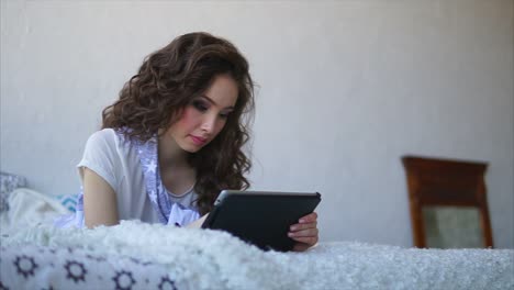 mujer joven usando tableta en la cama