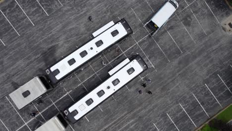 aerial view above a team disinfecting buses, to prevent a global pandemic - screwdriver, drone shot