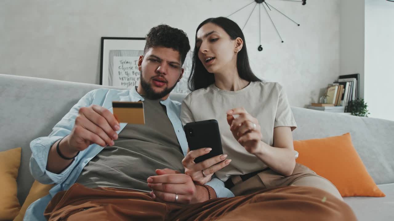 Happy Young Couple Ordering Food Using App On Smartphone