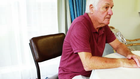 A-retired-man-sitting-at-table-alone