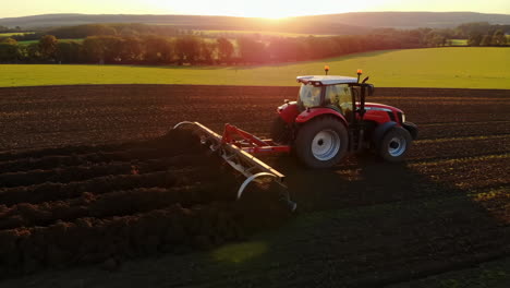 tractor plowing a field at sunset