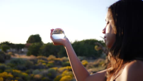 una bella maga sosteniendo una bola de cristal mágica y lanzando un hechizo en un mundo de fantasía