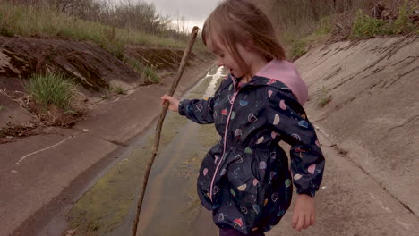 a little girl exploring a river diversion channel