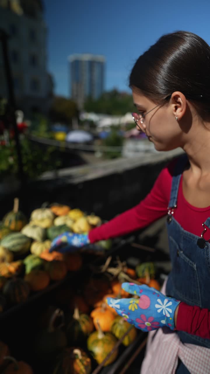 mujer recogiendo calabazas en un mercado al aire libre