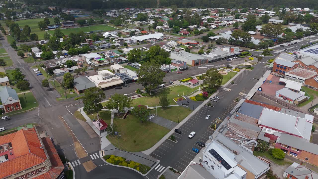 Aerial right-orbit captures Col Brown Rotary Park in Kurri Kurri, New South Wales, revealing open green lawns, tree-lined paths and community recreation areas nestled within the Hunter Region town.