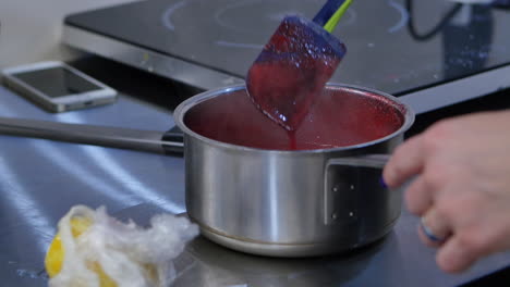 cooking or preparing a red fruit sauce/jam/dessert