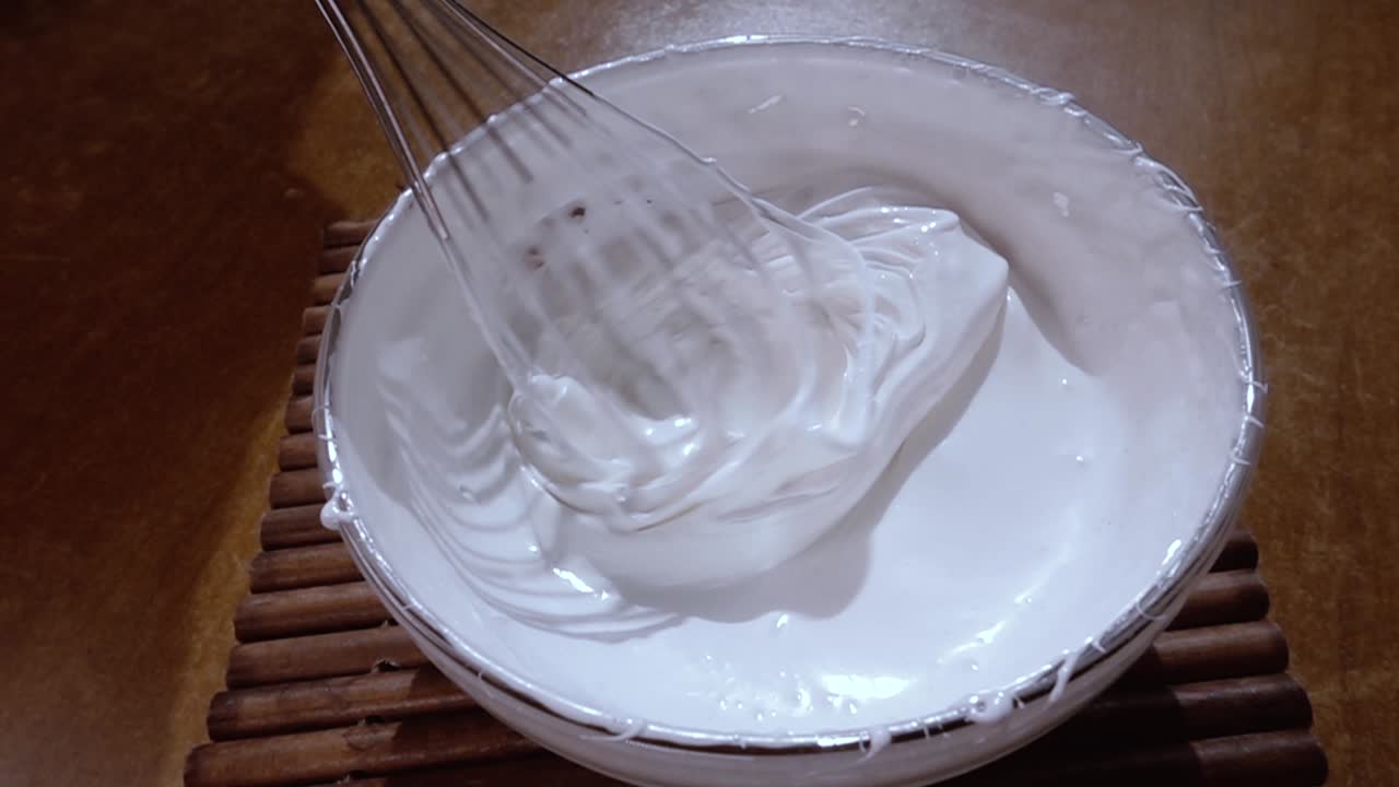 huevos batidos con azúcar usando un mezclador. cámara lenta con disparo de seguimiento de rotación.