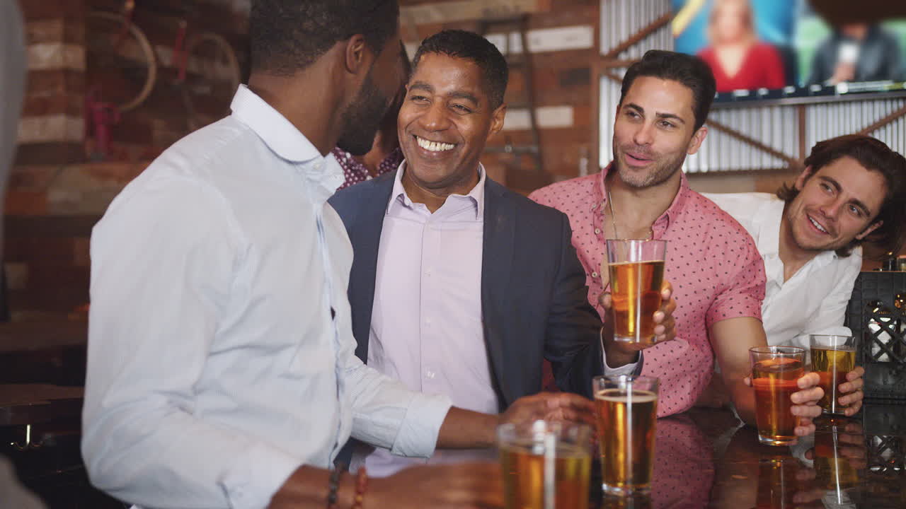grupo de amigos masculinos en la noche bebiendo cerveza en el bar juntos haciendo un brindis