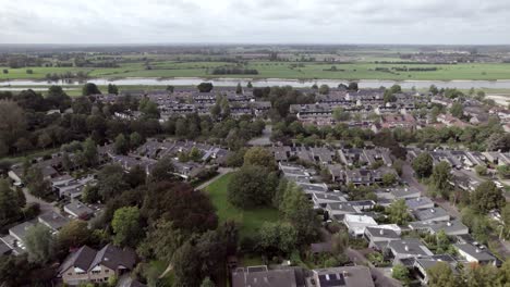 Backwards-movement-aerial-reveal-of-shopping-mal-car-parking-lot-in-Dutch-residential-neighbourhood