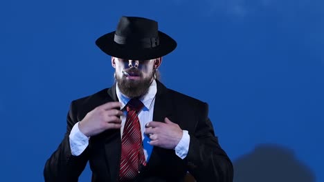 dramatic portrait of a man in a suit and hat smoking