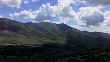 Wunderbarer-Flug-Mit-Einer-Drohne-In-Einem-Berggebiet,-Wo-Wir-Die-Beeindruckenden-Hochgebirgsreliefs-Und-Einen-Blauen-Himmel-Mit-Wolken-Sehen,-Die-Einen-Großen-Schatten-Auf-Den-Boden-Werfen-In-Gredos-Avila,-Spanien