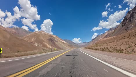 POV-shot-driving-through-the-dry-vast-scenic-mountain-range-in-Mendoza,-Argentina