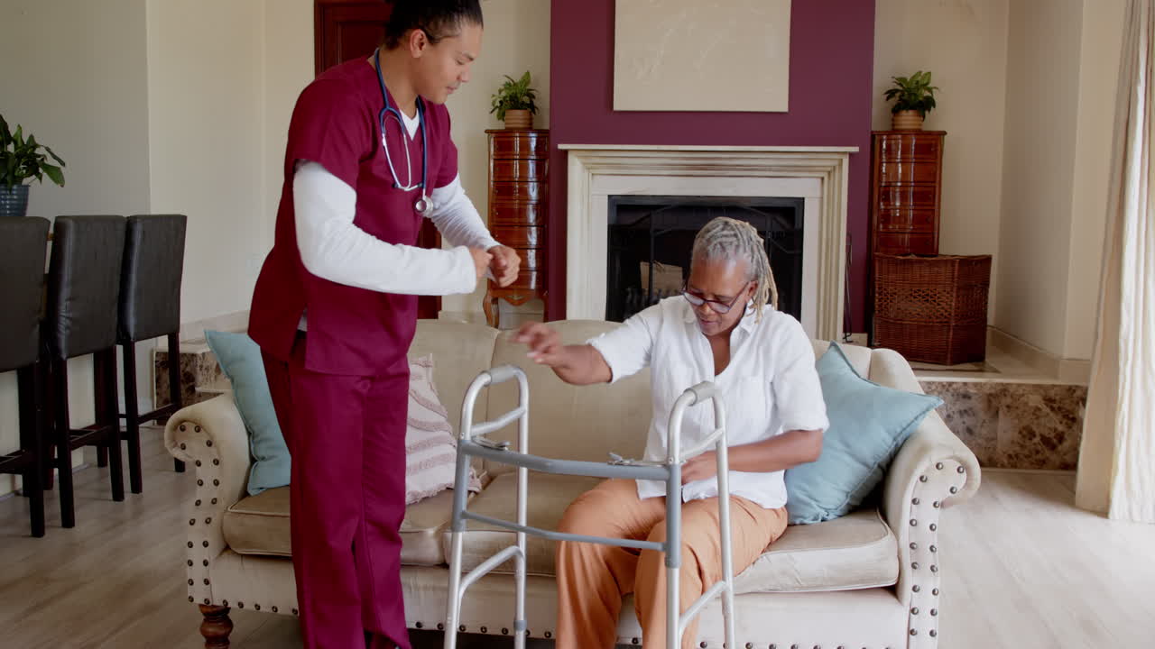 Assisting elderly woman with walker, caregiver providing support at home