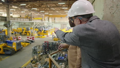 multiethnic engineers discussing manufacturing process in factory
