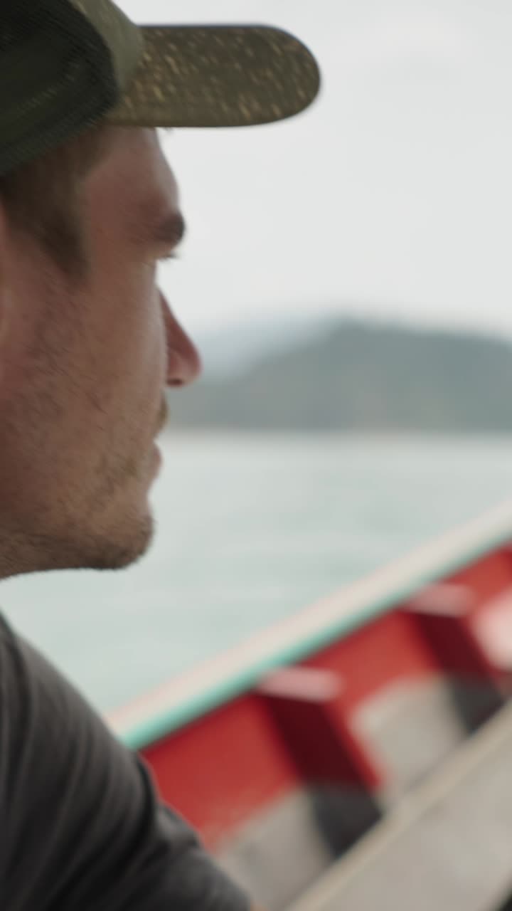 Uomo su una barca che guarda il mare