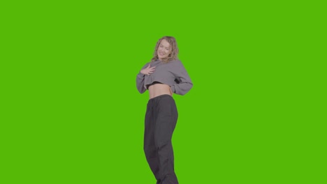 studio shot of young woman having fun dancing against green screen 31