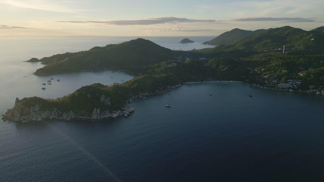 코타오 (koh tao) 에서 볼 수 있는 멋진 해가 지는 모습, 섬의 해안선과 평화로운 오렌지색 하늘과 함께 푸른 물이 그려져 있습니다.