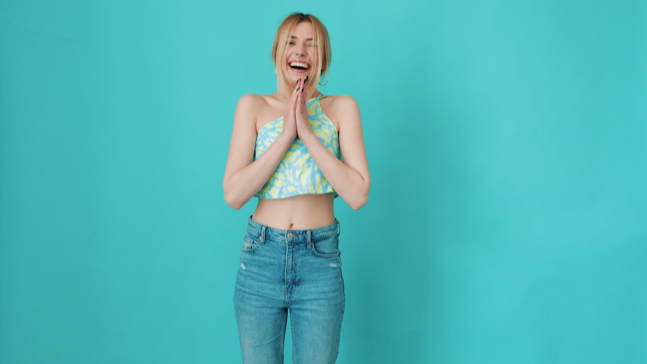y emocionada mujer asombrada posando cerca de la pared azul