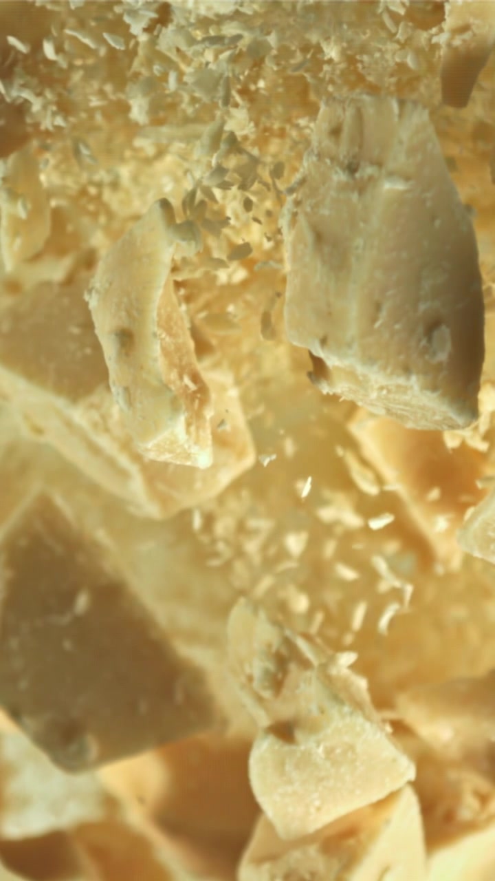 Parmesanoststykker og -krummer falder i slowmotion