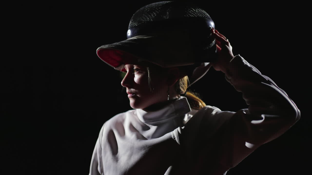 женская фехтовальщица в белой форме изображена на черном фоне.