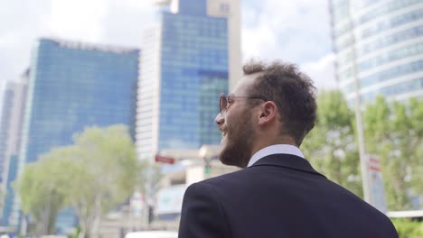 happy businessman walking by laughing.