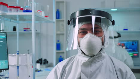 portrait of tired scientist man in ppe suit looking at camera