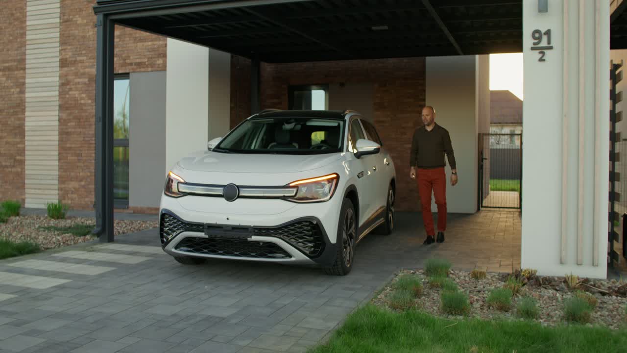 un suv blanco estacionado debajo de un porche en una casa moderna.