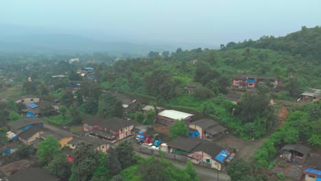 backwards-rising-crane-drone-shot-over-rural-Indian-village-on-hillside