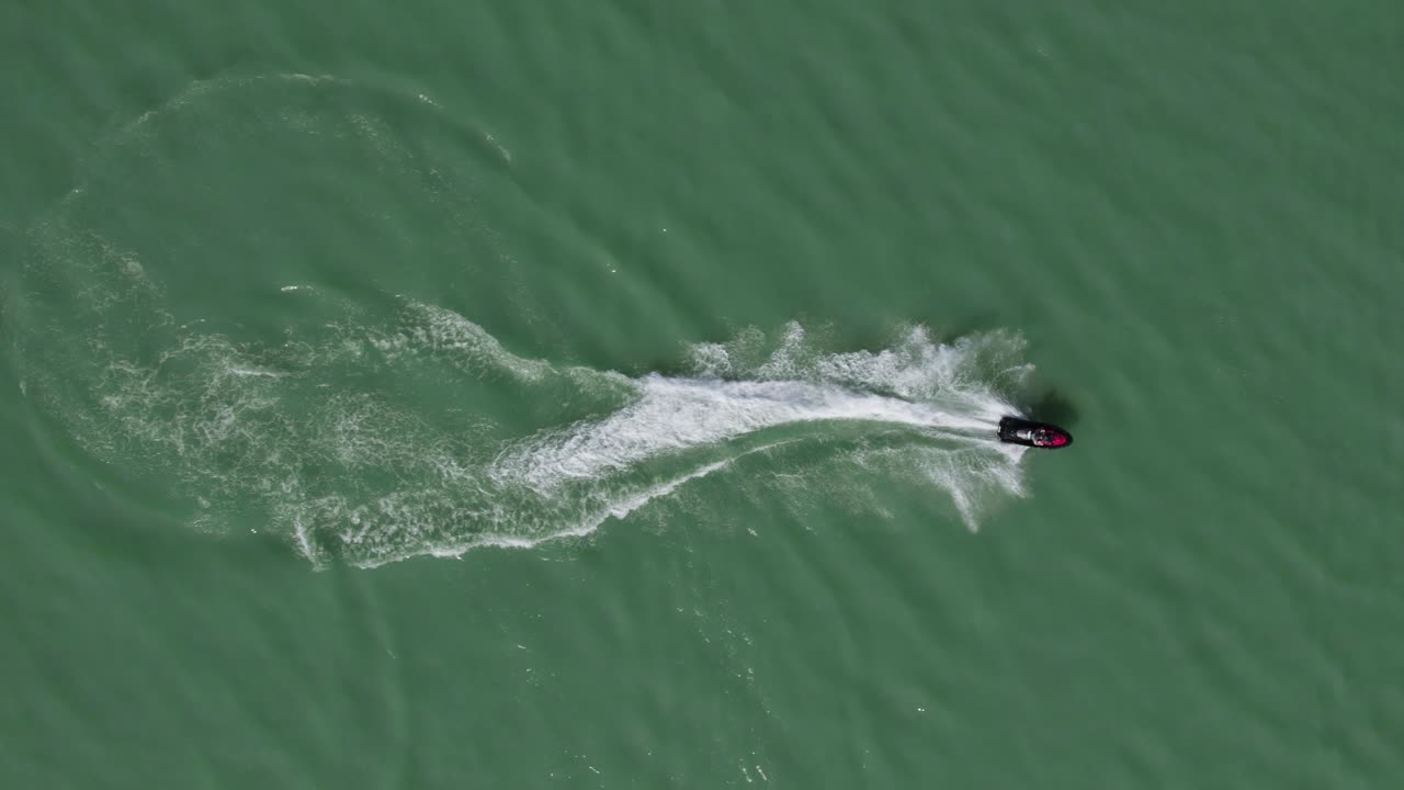 гонщик на гидроцикле sea doo мчится по водной глади озера, аэрофотосъемка сверху