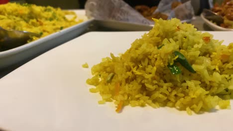 Close-Up-View-Of-Spoon-Serving-Healthy-Fried-Rice-Onto-Plate