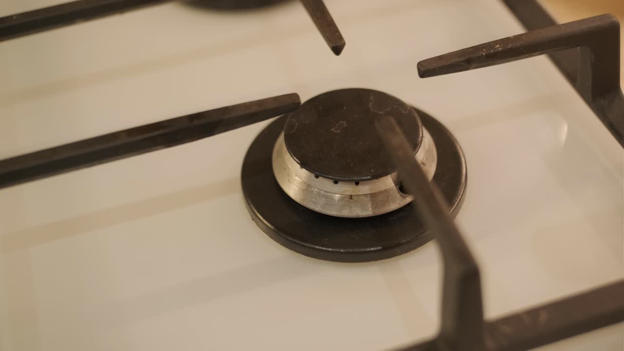 Gasskomfyrbrenner som tenner med blå flamme.