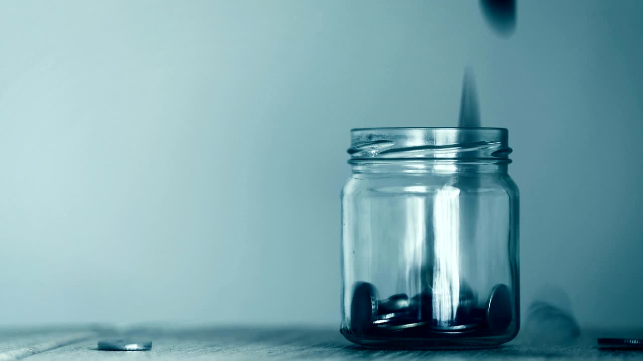 cerca de la moneda de dinero cayendo en un frasco de vidrio, un ahorro de dinero, donación o negocio concepto de crecimiento financiero, resolución 4k dci, tono de color vintage retro