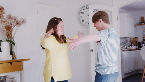 young downs syndrome couple having fun dancing at home together