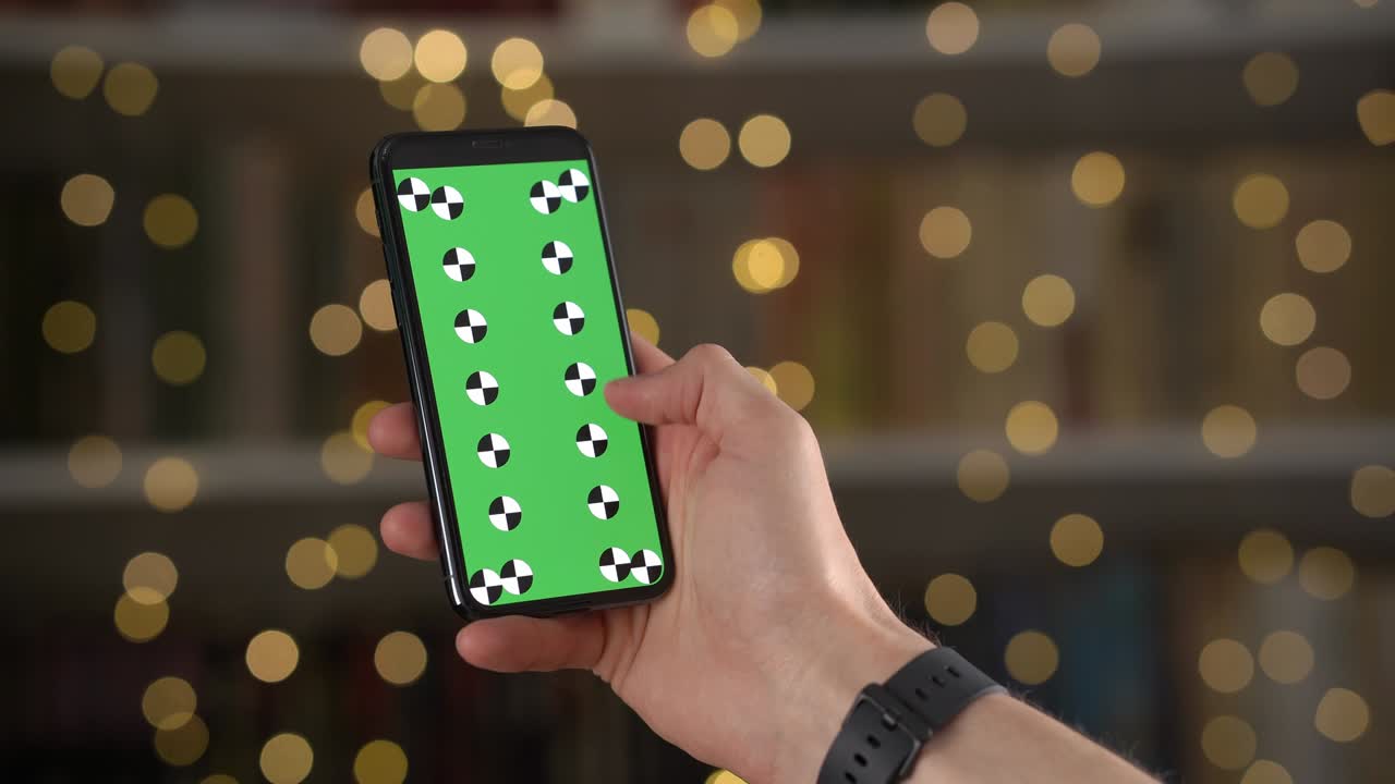 Man swipes up and down then taps on smartphone display with tracking markers in closeup
